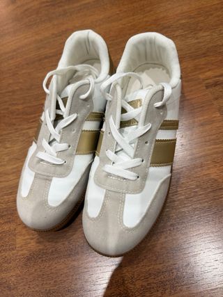 Zapatillas deportivas blancas y doradas