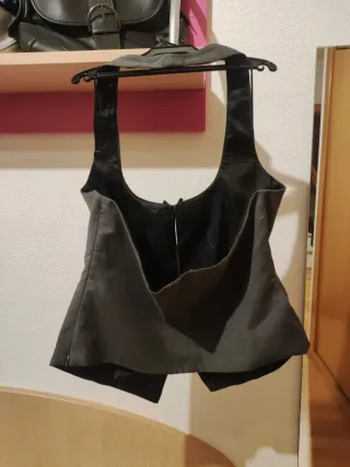 Chaleco Zara gris con lazos negros.