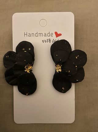 Pendientes flor negra con detalles dorados.