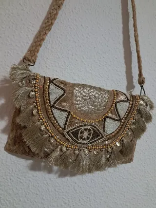 Bolso de mano dorado con flecos