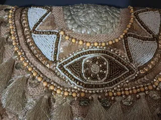 Bolso de mano dorado con flecos