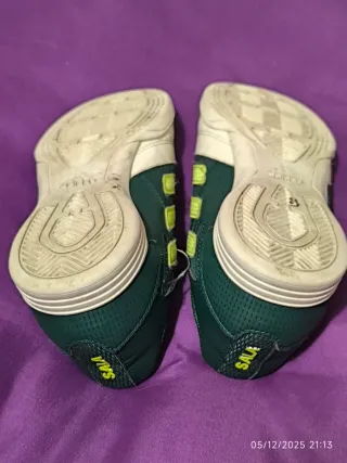 Botas de fútbol sala Adidas verdes y blancas.