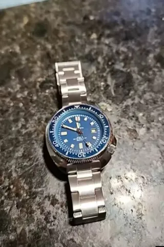 Reloj analógico plateado y azul