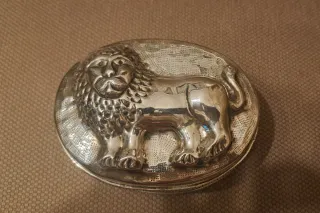 Caja metálica con león en relieve