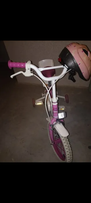 Bicicleta infantil rosa con casco