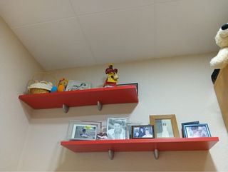 Cama individual roja con cajones y estanterías