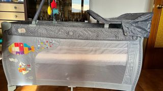 Cuna de viaje gris con cambiador