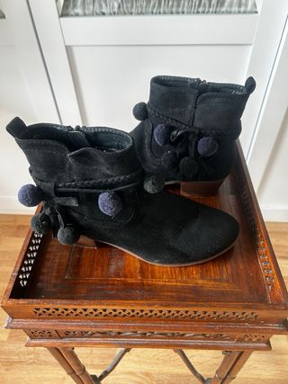 Botines negros con pompones y flecos