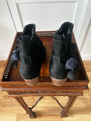 Botines negros con pompones y flecos