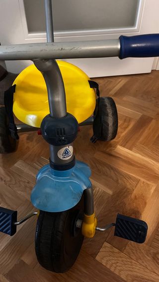 Triciclo infantil amarillo y azul.
