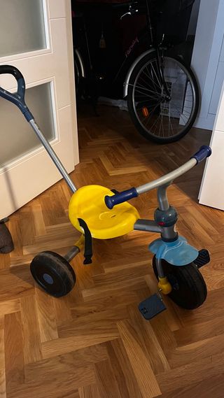 Triciclo infantil amarillo y azul.