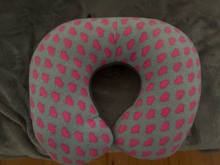 Almohada de viaje gris con corazones rosas