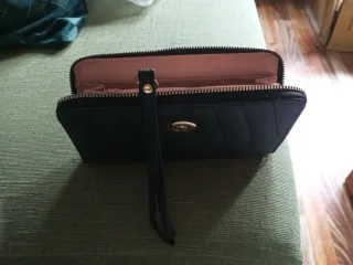 Cartera de mano negra con pompón