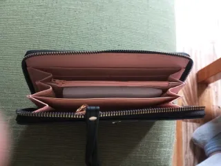 Cartera de mano negra con pompón