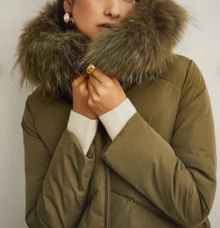 Plumífero verde con capucha de pelo