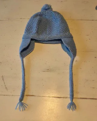 Gorro tejido azul con orejeras y pompón