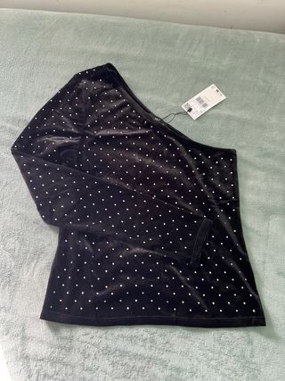 Top asimétrico negro con pedrería