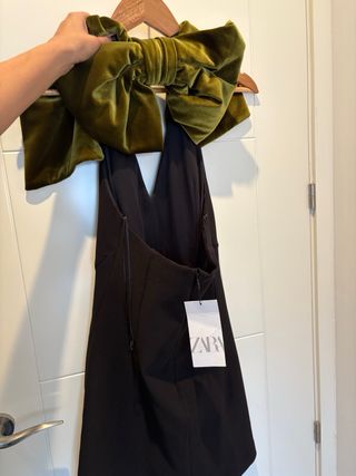 Vestido negro fiesta con detalle de lazo verde.