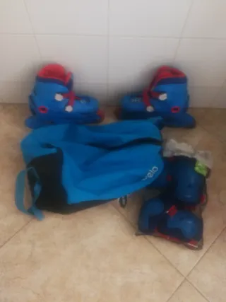 Patines, protecciones infantiles azules y bolsa.