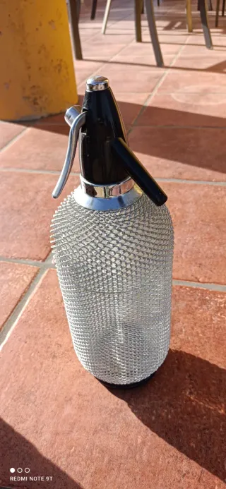 Sifón de agua con malla metálica.