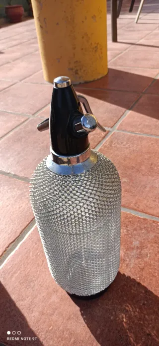 Sifón de agua con malla metálica.