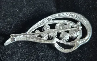 Broche plateado con piedras rosas