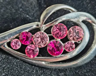 Broche plateado con piedras rosas