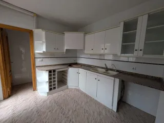 Muebles de cocina blancos con encimera de granito.