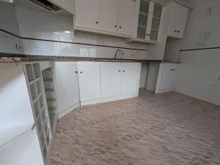 Muebles de cocina blancos con encimera de granito.