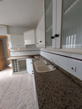 Muebles de cocina blancos con encimera de granito.