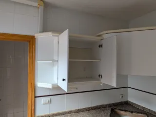 Muebles de cocina blancos con encimera de granito.