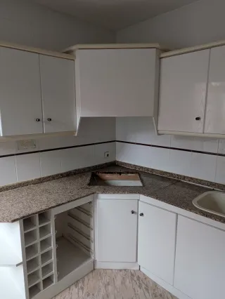 Muebles de cocina blancos con encimera de granito.