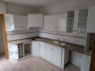 Muebles de cocina blancos con encimera de granito.