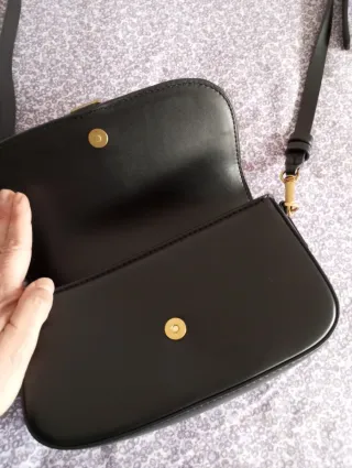 Bolso negro con hebilla dorada
