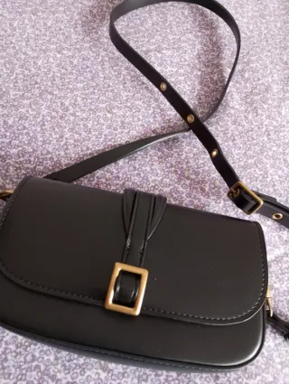 Bolso negro con hebilla dorada