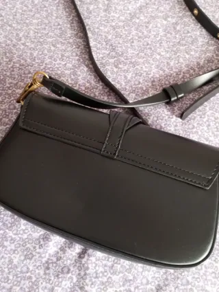 Bolso negro con hebilla dorada