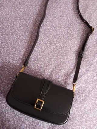 Bolso negro con hebilla dorada