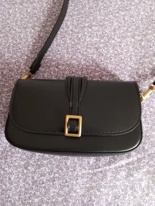 Bolso negro con hebilla dorada