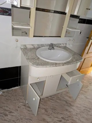 Mueble de baño con lavabo de mármol y espejo