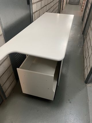 Mueble de madera blanco con cajón extraible.