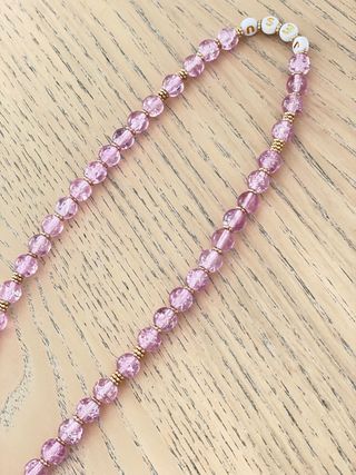 Rosario de cuentas rosas y detalles dorados