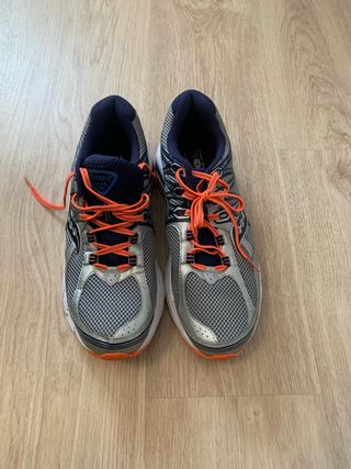 Zapatillas running Saucony plateadas y naranjas