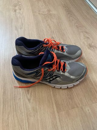 Zapatillas running Saucony plateadas y naranjas