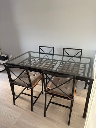 Mesa de metal y cristal con sillas