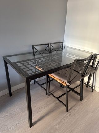 Mesa de metal y cristal con sillas