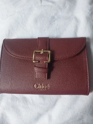 Cartera granate con hebilla dorada.nueva