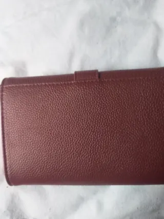 Cartera granate con hebilla dorada.nueva
