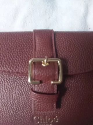 Cartera granate con hebilla dorada.nueva