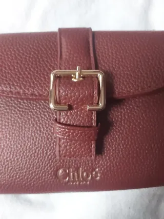 Cartera granate con hebilla dorada.nueva