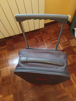 Maleta de viaje gris con detalles rojos